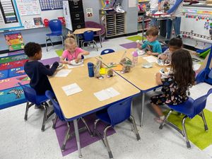 PreK students enjoy a snack after making bird feeders